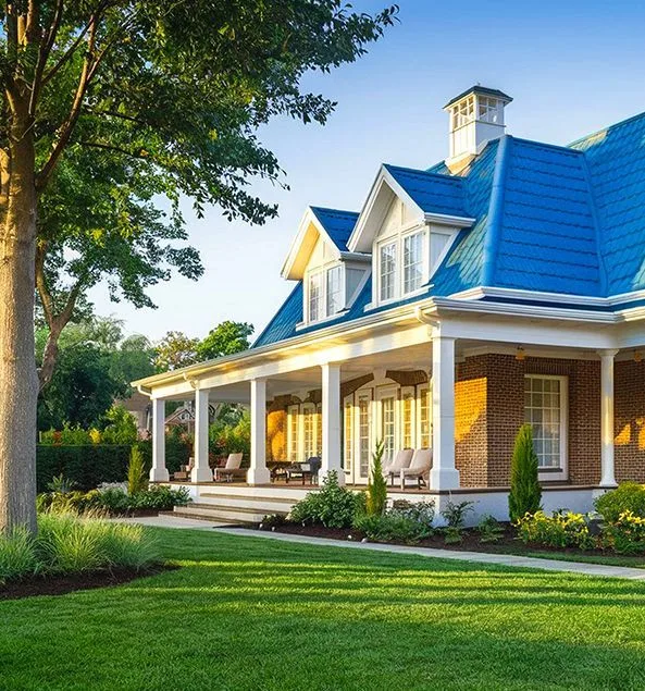 Brick home with a blue roof, white columns, and a wraparound front porch