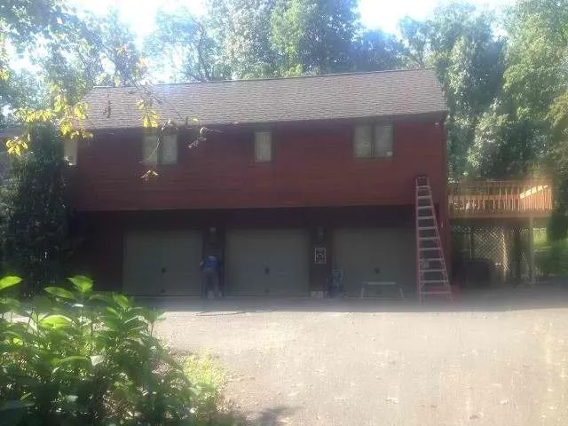 Wood-sided home with a three-car garage after exterior painting