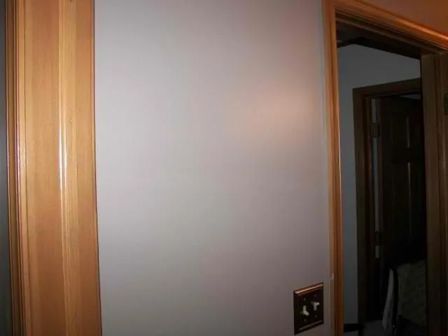 Light gray painted wall framed by natural wood trim and doorways