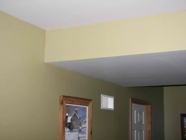 Room with sage green walls and a cream painted soffit